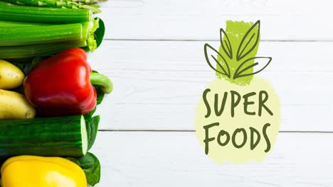 Animation-of-super-foods-text-in-green-over-fresh-organic-vegetables-on-wooden-boards