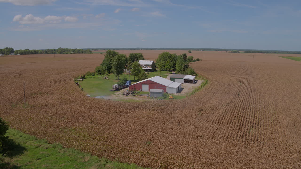 Aerial of a barn, farm, and homestead in farmland in the midwest