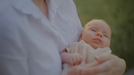 smiling woman holding newborn at sunset