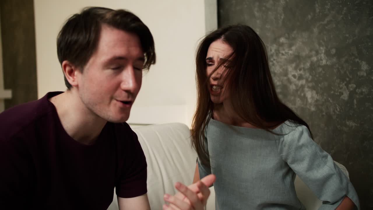 Couple quarrelling sitting on couch at home. Family conflicts, difficult relationships