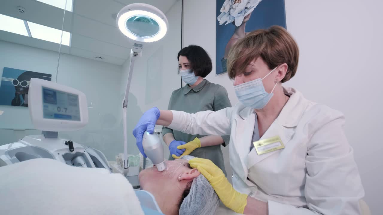 전문적인 얼굴 피부 재생, 리프팅 절차. 미용사는 현대적인 초음파 장치를 사용합니다. 하드웨어 미용