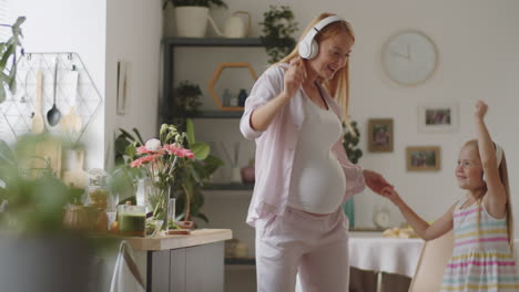 mother and daughter dancing in kitchen