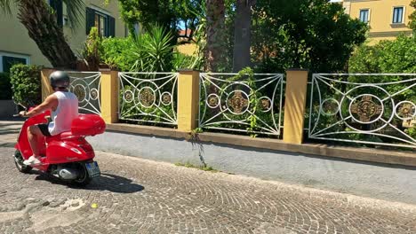 person rides a red moped in sorrento