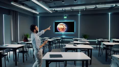 teacher pointing at a holographic projection of earth in a modern classroom.
