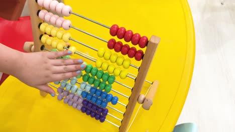 kids interact with colorful abacus beads