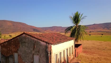 Low-drone-shot-flying-slowly-over-an-abandoned-farmhouse-in-rural-Bahia,-Brazil