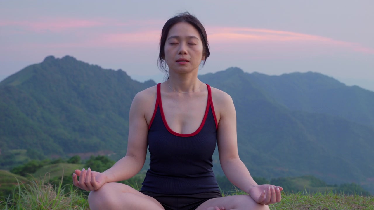 寧靜的女子閉目盤坐蓮花式，在越南毛山（Mau Son）的日落山脊上冥想，體現平靜與正念。