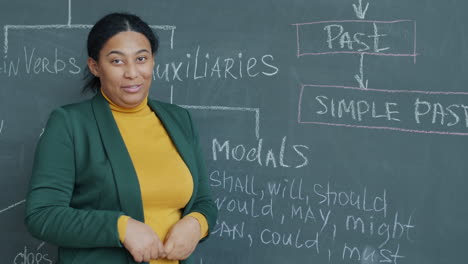 teacher explaining past tense and modals on a blackboard