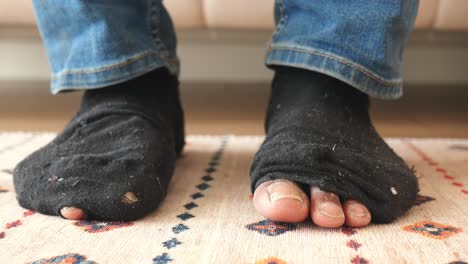 a pair of worn out black socks with holes in them