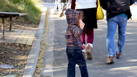 child and adults walking together in park