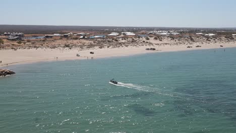 4K-Little-boat-arriving-landing-to-the-beach-coast-in-green-turquoise-ocean-water