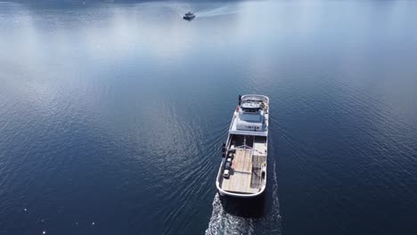 Ferry-Oppedal-from-Norled-company-is-transporting-cars-and-passengers-across-Norwegian-Sognefjord-during-sunny-summer-day---Aerial-above-and-behind-ferry-during-open-sea-crossing