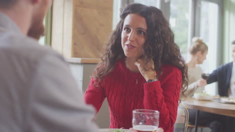 Una-Pareja-Joven-Sonriente-En-Una-Cita-Disfrutando-Juntos-De-Una-Pizza-En-Un-Restaurante