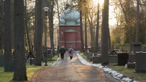 Älteres-Paar,-Das-Während-Des-Sonnenuntergangs-Auf-Einem-Friedhof-Spaziert