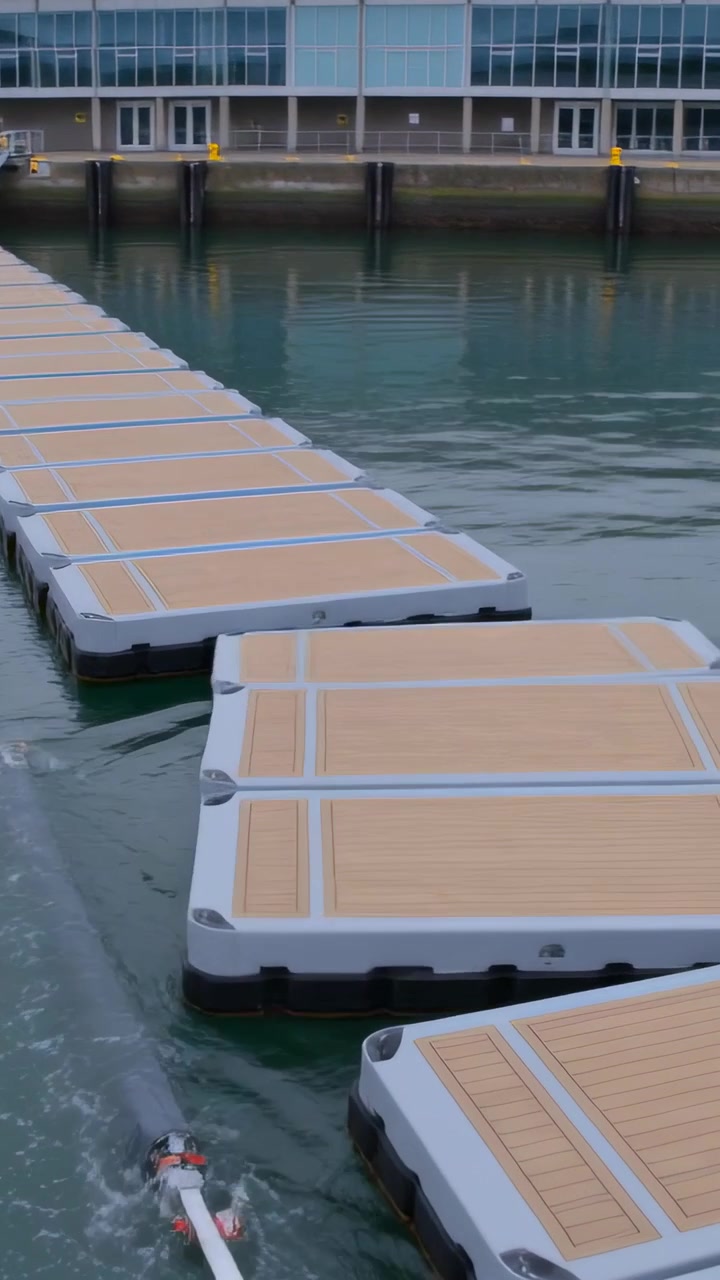 Video verticale: Pontile galleggiante che reagisce alla scia, ruotando e assestandosi alla banchina accanto ai tubi guida.