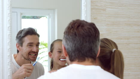 Little-girl-brushing-her-teeth-with-father