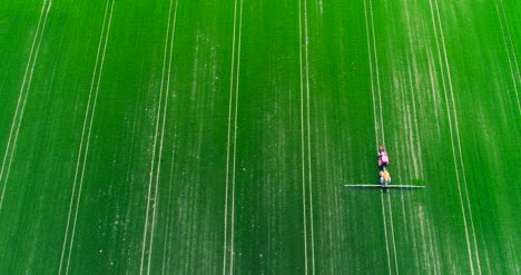 Toma-Aérea-Del-Campo-De-Pulverización-Del-Tractor-Con-Productos-Químicos