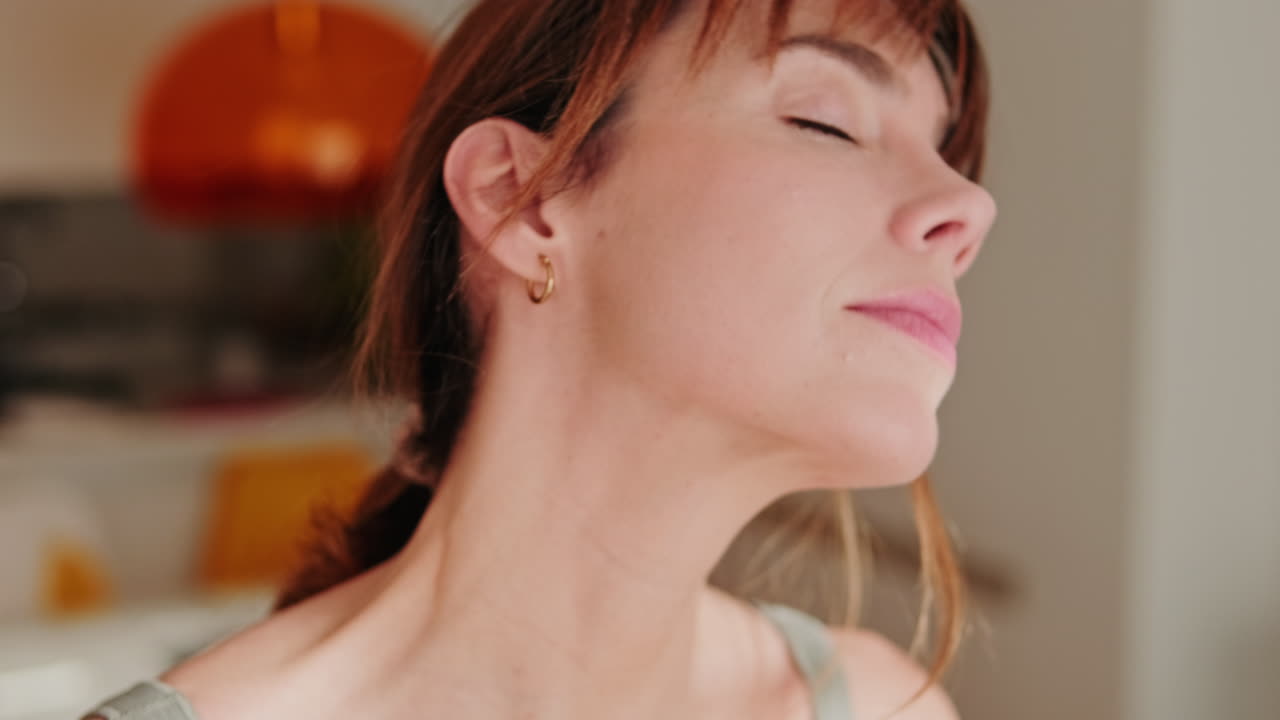 Primo piano di donna che distende il collo con gli occhi chiusi