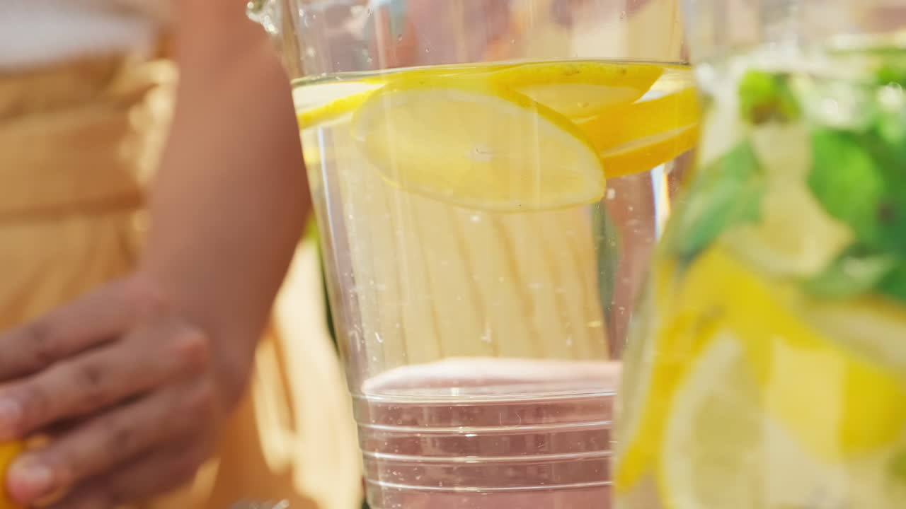 Adding Lemon Slice Into Lemonade In Glass Decanter