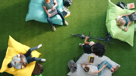 Group-of-diverse-students-using-technology-sitting