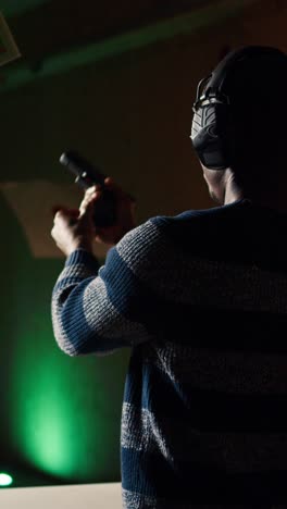 vertical video man leaving indoor shooting ground after finishing firing weapon