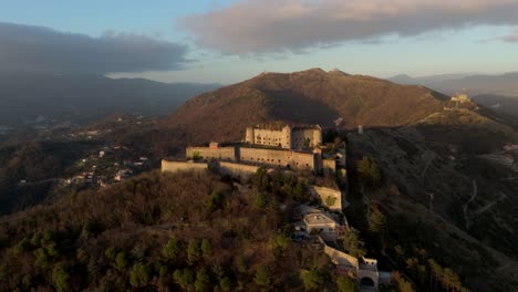 forte sperone at sunset with surrounding forest and mountains in genoa, italy, aerial view