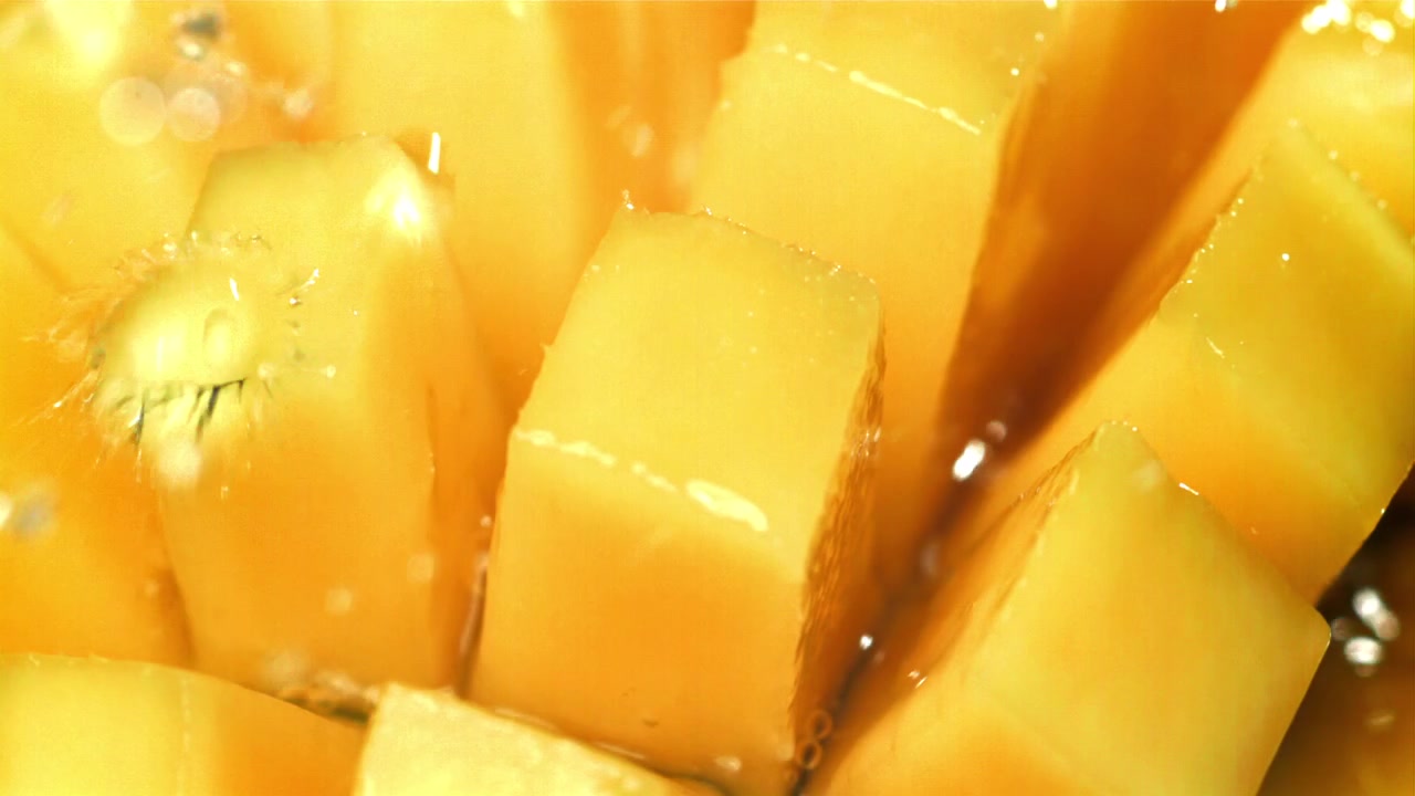 Orzeźwiająca woda rozpryskująca się na soczyste kostki mango