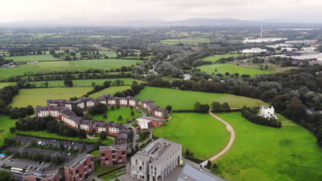 aerial view, university of limerick buildings campus, green landscape of ireland on cloudy summer day, drone shot