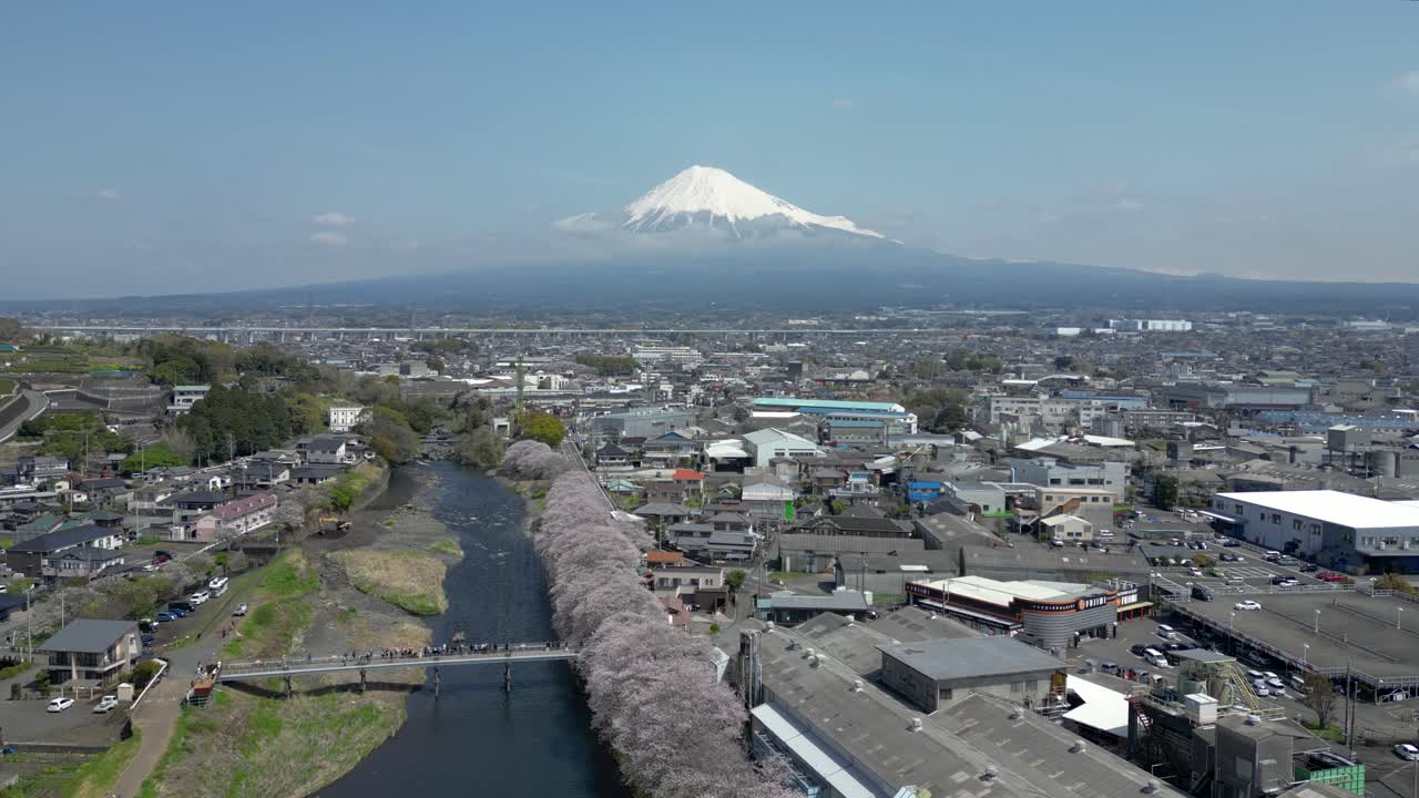 Cinematic drone forward flight over river Sakura with Mt. Fuji in distance