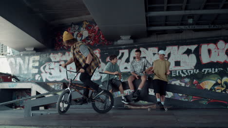 스케이트 파크에서 그래피티와 함께 bmx 자전거에서 점프 트릭을 수행하는 스포츠 남자.