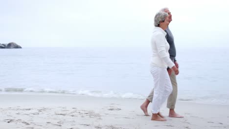 mature couple walking on the sand