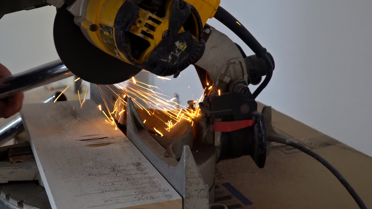 ремесленник пилает металл с помощью дискового шлифователя в искрах во время шлифования железа