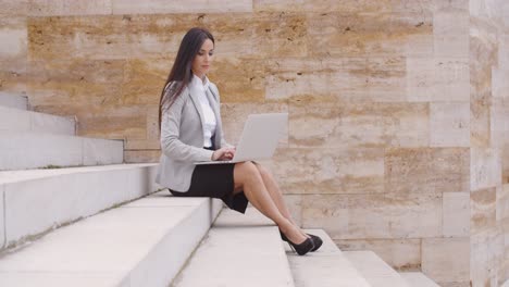 Low-angle-view-of-woman-using-laptop-outdoors