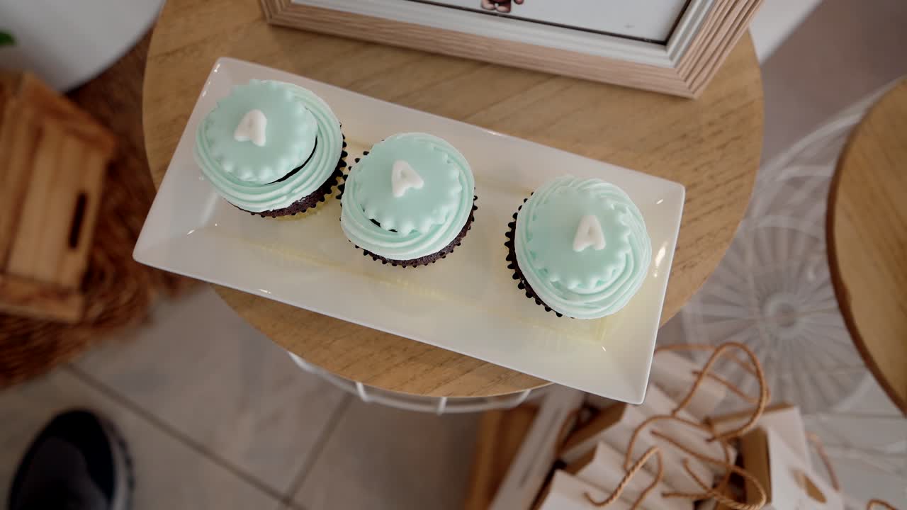 cupcakes with blue icing and letter A set on elegant party dessert table