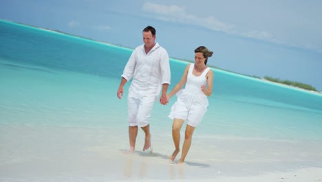 loving caucasian couple holding hands on caribbean beach