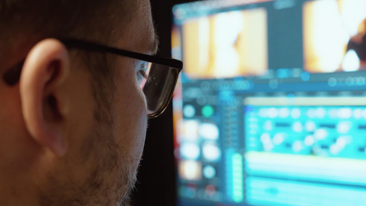 A man works in a professional video editing software, pointing at the timeline to review cuts and effects. Concept for post-production, teamwork, and creative workflow