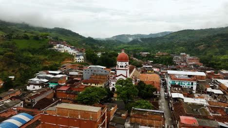 Drone-shot-orbiting-the-Saint-Raphael's-Church-in-cloudy-San-Rafael,-Colombia