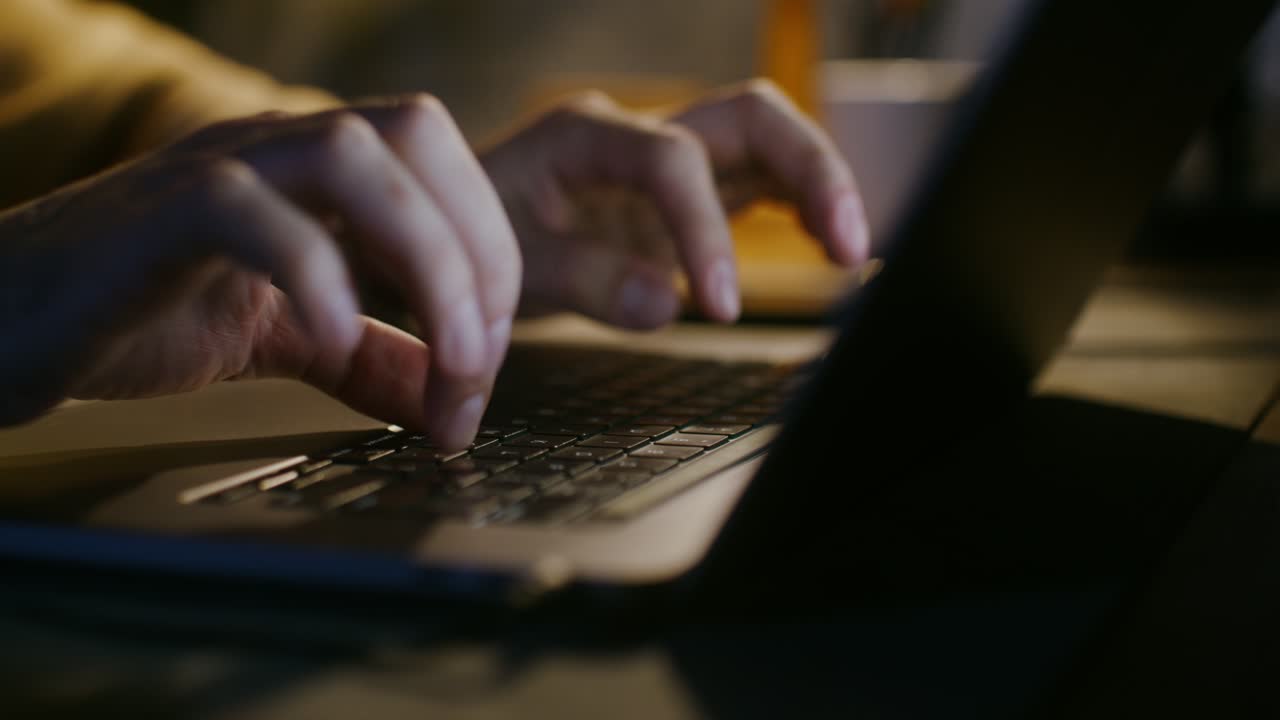 Persoon die's nachts op de laptop typt