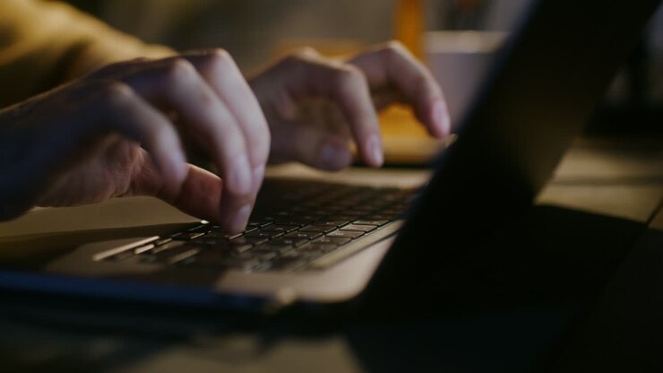Person Typing on Laptop at Night