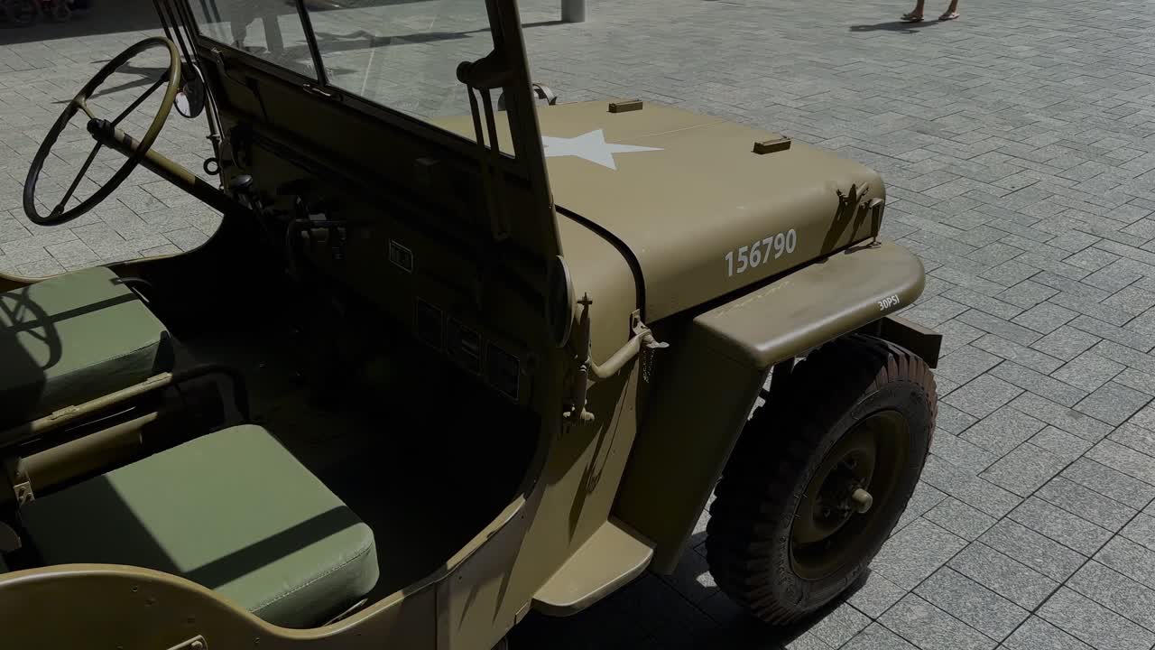 US Army jeep military vehicle on display from rear side - khaki left hand drive