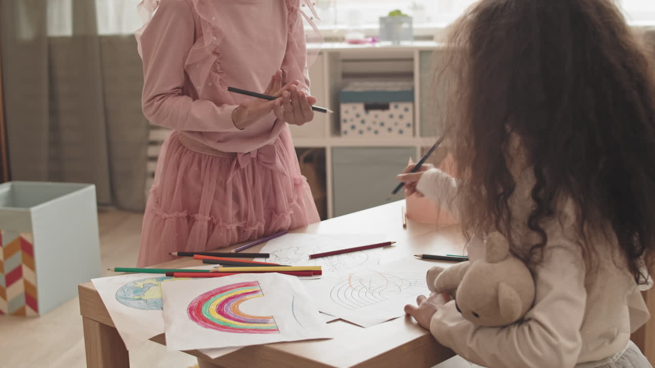 Mixed-Race Sisters Doodling over Pictures