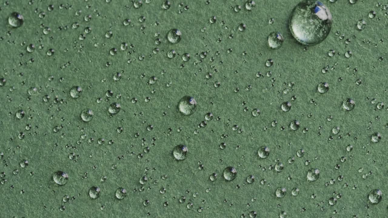 micro vídeo de primer plano de gotas de agua con espacio de copia en fondo verde