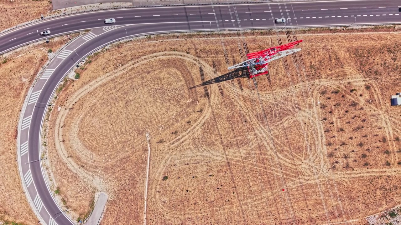 Curva di una strada vicino a una torre in un paesaggio arido