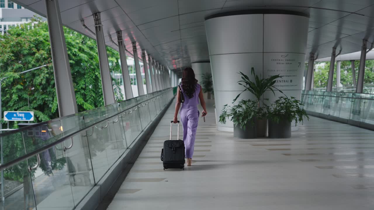 Woman Walking on a Footbridge with Suitcase