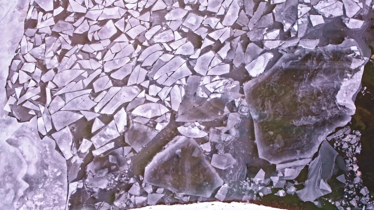 Toma de dron que captura la quietud del invierno con el hielo congelado de los Grandes Lagos extendiéndose por la superficie inferior