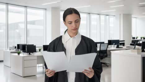 serious indian female lawyer reading case files