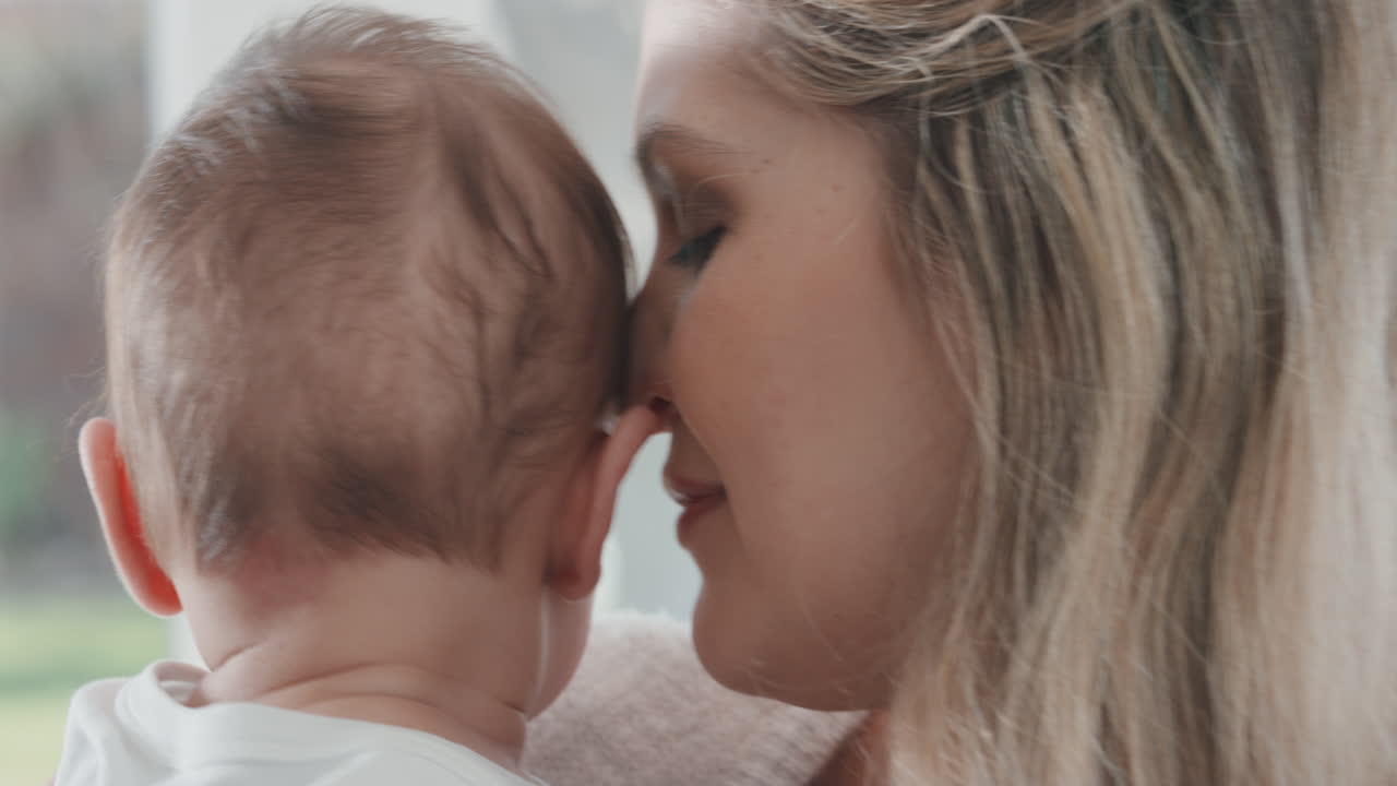 엄마는 아기를 안고 신생아를 진정시키고 엄마는 부드럽게 아기를 진정시켜 집에서 양육하는 모성 생활을 즐긴다 4k