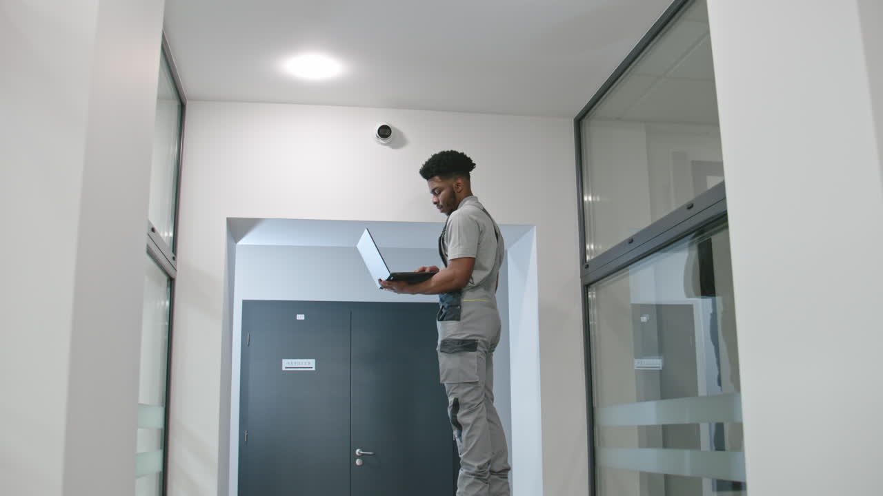 trabajador que utiliza una computadora portátil en un edificio de oficinas