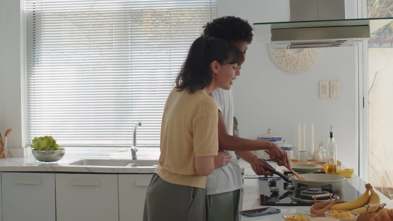 Wife Hugging Husband when He Cooking Breakfast