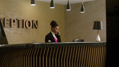 Recepcionista-Hablando-Por-Teléfono-En-El-Hotel